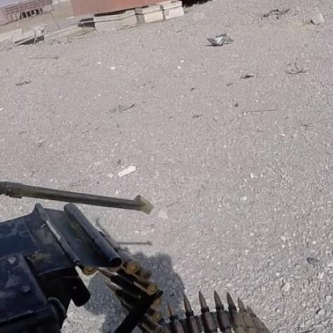 gunner aims machine gun at a road